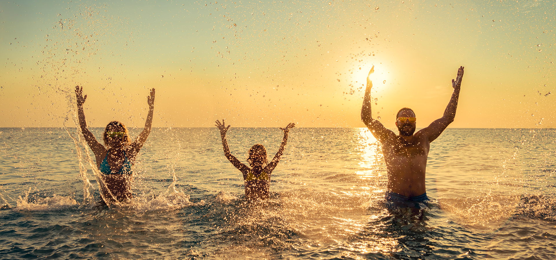 Family in the water at sunset